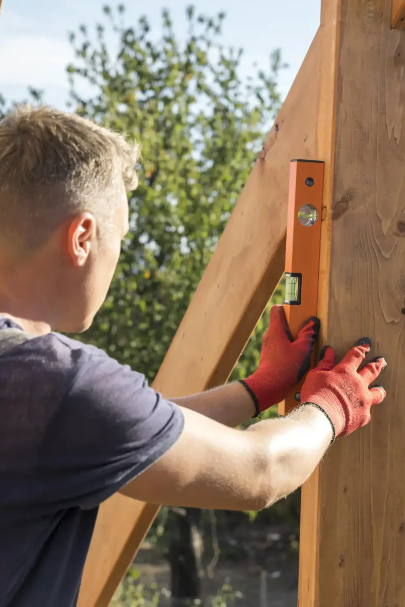 carpenter-man-taking-measures-wood-plank-ezgif.com-optiwebp